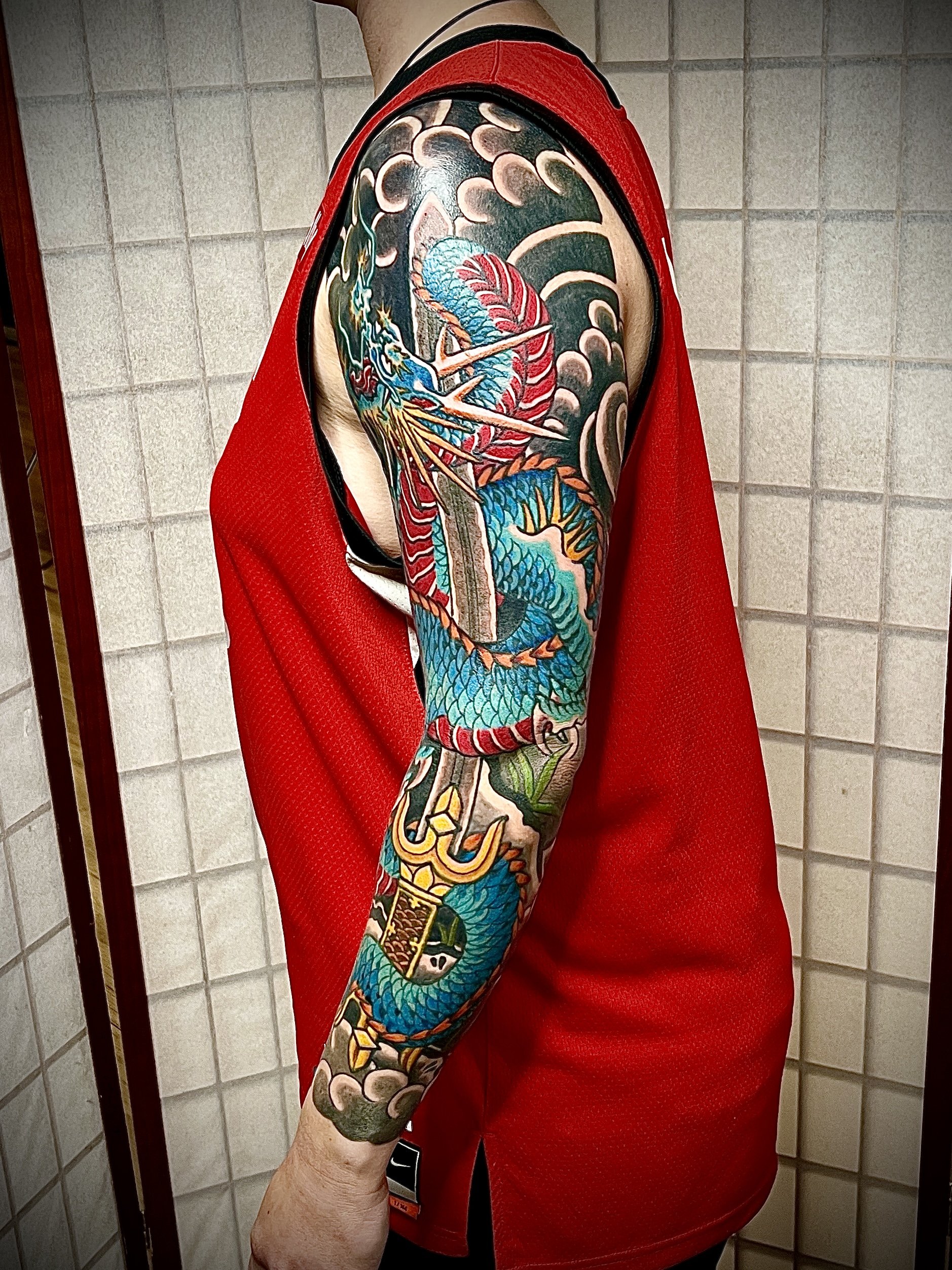 A turquoise and red Japanese dragon sleeve by Cam Kelley