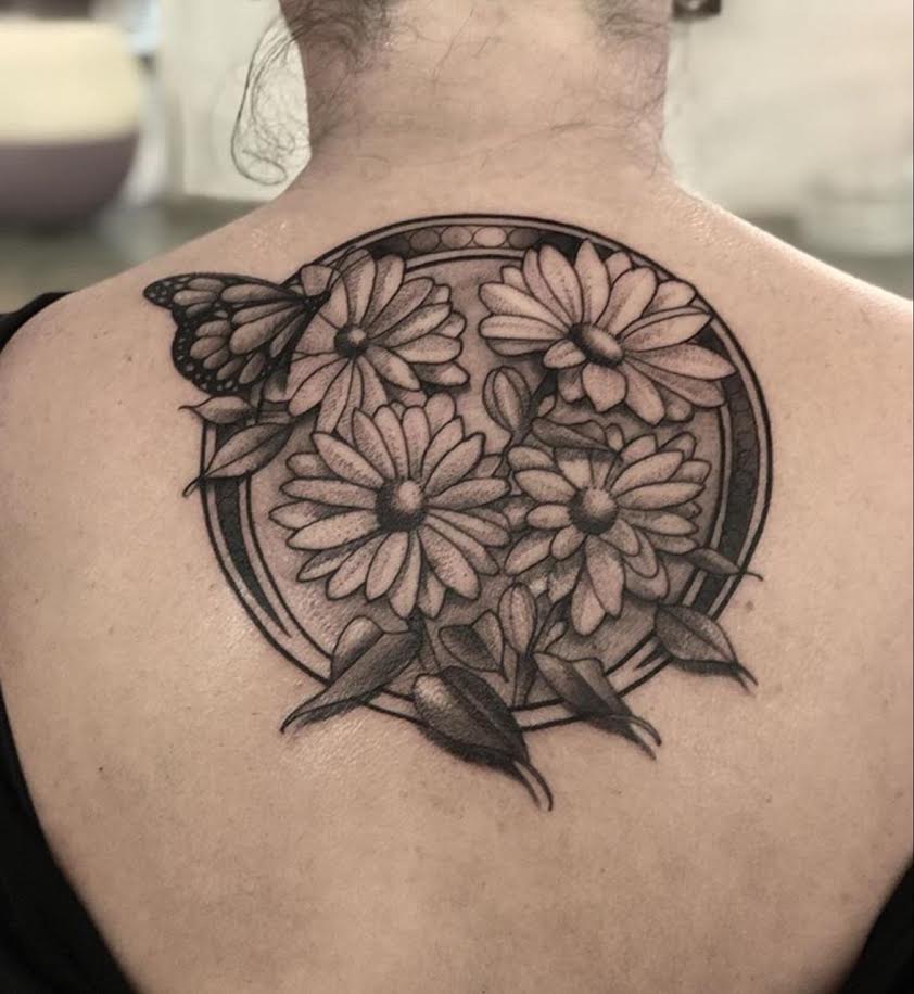 A floral and butterfly upper-back tattoo by Josh Echevarria